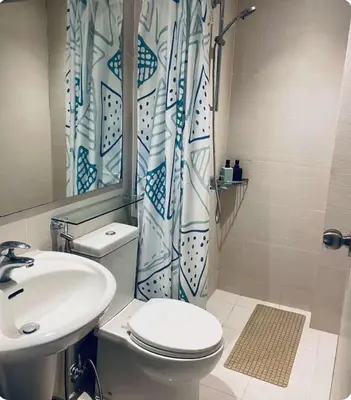 a bathroom with a sink and a toilet and a shower curtain at Man-made beach waves 19 minutes from NAIA in Manila