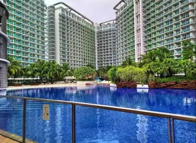 a large swimming pool in the middle of two large buildings at Man-made beach waves 19 minutes from NAIA in Manila