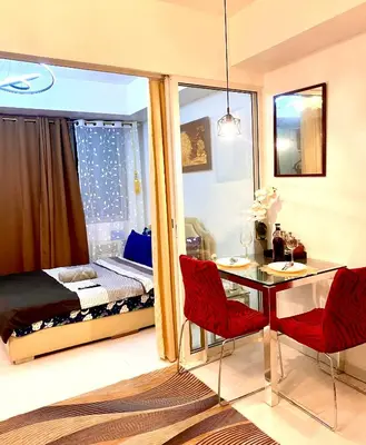 a room with a bed and a table and chairs at Man-made beach waves 19 minutes from NAIA in Manila