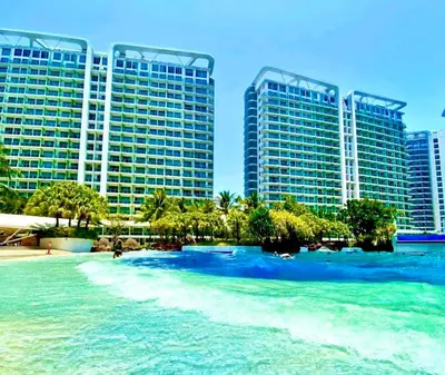 a view of a beach with tall buildings at Man-made beach waves 19 minutes from NAIA in Manila