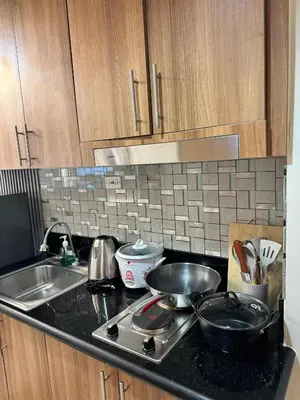 a kitchen counter with a stove and a sink at Milagrosa Shore 3 residences in Manila