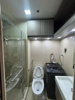 a bathroom with a toilet and a shower and a sink at Milagrosa Shore 3 residences in Manila