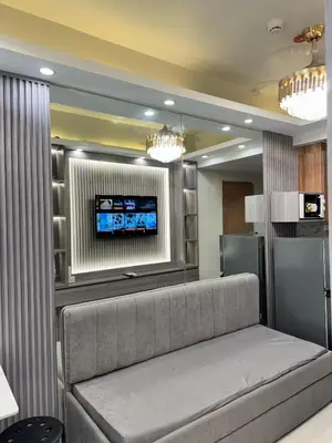 a living room with a couch and a tv at Milagrosa Shore 3 residences in Manila