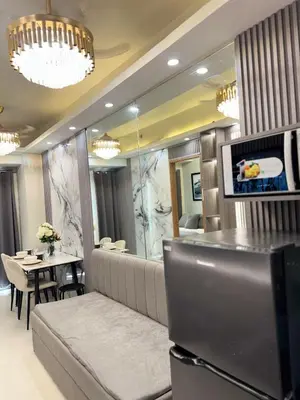 a dining room with a table and a mirror at Milagrosa Shore 3 residences in Manila