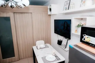 a small living room with a table and a tv at Staycation near Moa new room in Manila