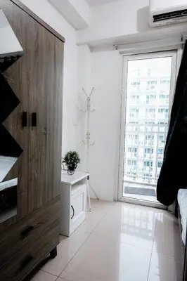 a white room with a large window and a plant on a table at Staycation near Moa new room in Manila