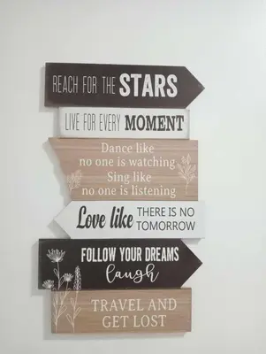 a stack of wooden signs hanging on a wall at Downtown Makati Malls and Bars at your doorsteps in Manila