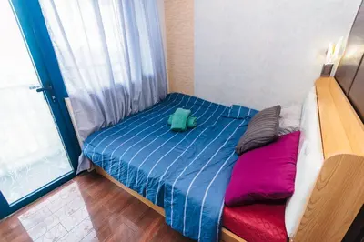 a small bedroom with a bed with a green bag on it at Eccentric Escape Stylish Makati Urban Swim Gym 4034 in Manila