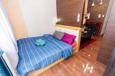a bedroom with a bed with purple and pink pillows at Eccentric Escape Stylish Makati Urban Swim Gym 4034 in Manila