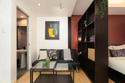 a living room with a couch and a glass table at Tranquil Greenbelt Makati Condo - Free Pool Access in Manila