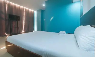 a bedroom with a large white bed with a blue wall at Ranchotel General Trias Cavite by RedDoorz in Uldugan