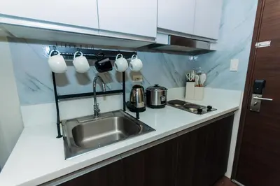 a kitchen with a sink and a counter with coffee mugs at Boutique Air Retreat Relax Laugh Swim Gym Car Park 1767 in Manila