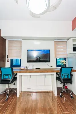 a desk with two chairs and a tv on a wall at Boutique Air Retreat Relax Laugh Swim Gym Car Park 1767 in Manila