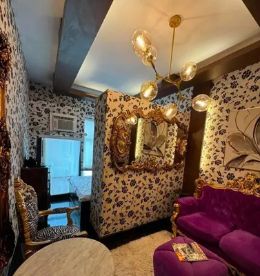a living room with a purple couch and a mirror at Casa Makati in Manila