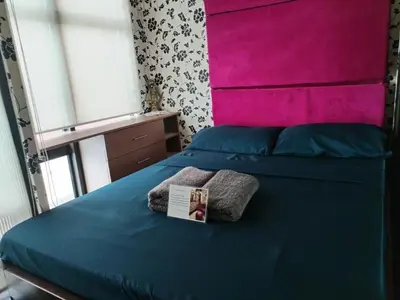 a bedroom with a blue bed with a pink headboard at Casa Makati in Manila