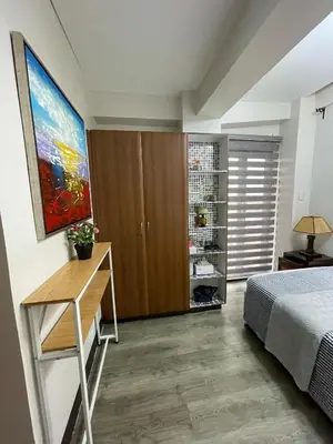 a bedroom with a bed and a desk and a painting at Resorts world condotel High speed wifi in Manila