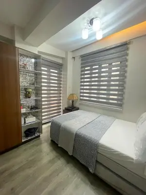 a bedroom with a bed and a window with blinds at Resorts world condotel High speed wifi in Manila