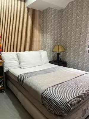 a bedroom with a bed and a lamp on a table at Resorts world condotel High speed wifi in Manila