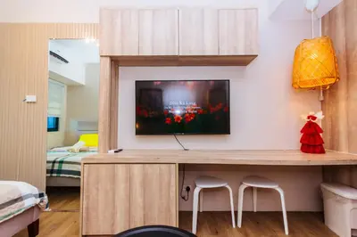 a room with a tv on a wall with two stools at The Laughing Loft Cosmopolitan Comfort Gym Swim Park 2428 in Manila