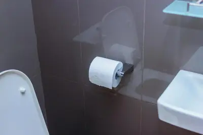 a toilet paper dispenser on a wall next to a sink at The Laughing Loft Cosmopolitan Comfort Gym Swim Park 2428 in Manila