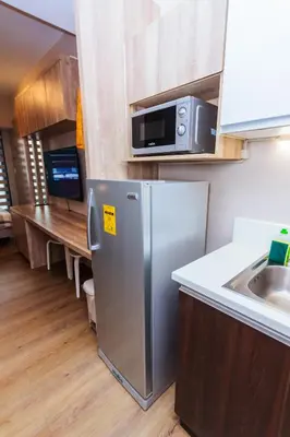 a kitchen with a stainless steel refrigerator and a sink at The Laughing Loft Cosmopolitan Comfort Gym Swim Park 2428 in Manila