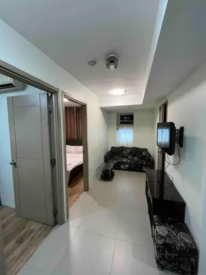 a living room with a couch and a television at The Serenity Tower 2706 in Manila