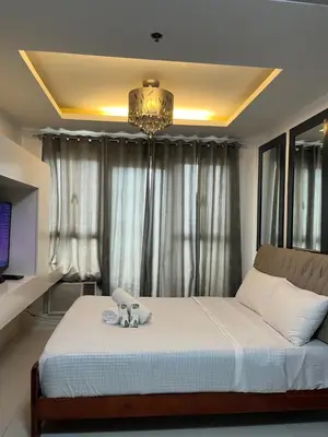 a bedroom with a bed and a chandelier at Kiean Leases in Manila