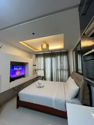 a bedroom with a bed and a flat screen tv at Kiean Leases in Manila