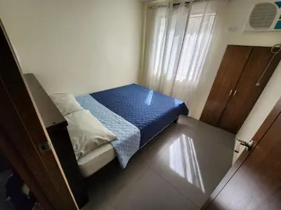 a small bedroom with a bed with a blue blanket at Jerry's Homestay in Manila