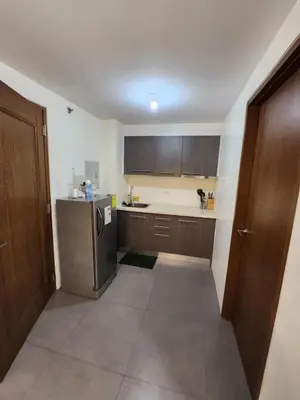 a kitchen with wooden cabinets and a stainless steel refrigerator at Jerry's Homestay in Manila