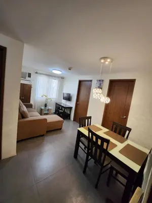 a dining room and living room with a table and chairs at Jerry's Homestay in Manila