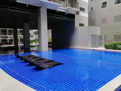 a large swimming pool with blue tiles in a building at Happy Home Haven At S Residences Moa in Manila