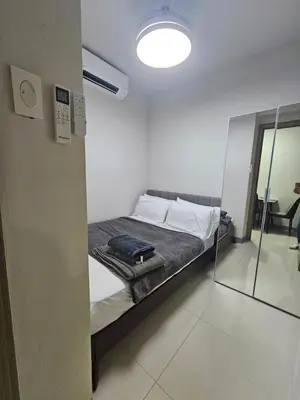 a bed in a room with a mirror at Happy Home Haven At S Residences Moa in Manila