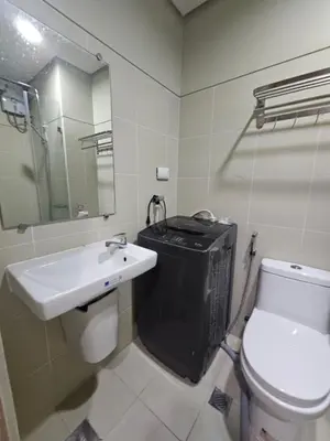 a bathroom with a sink and a toilet and a mirror at Happy Home Haven At S Residences Moa in Manila