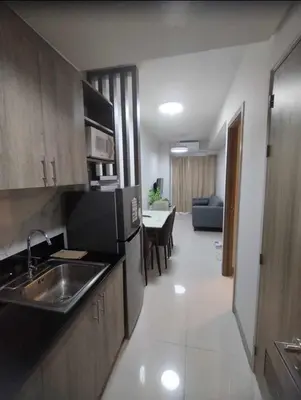 a kitchen with a sink and a living room at Happy Home Haven At S Residences Moa in Manila