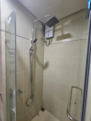 a shower with a glass door in a bathroom at Happy Home Haven At S Residences Moa in Manila