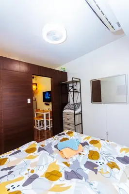 a bedroom with a bed with a floral bedspread at Serene City Stay Trendy Cozy Makati Condo Fun Swim Gym Netflix 4047 in Manila
