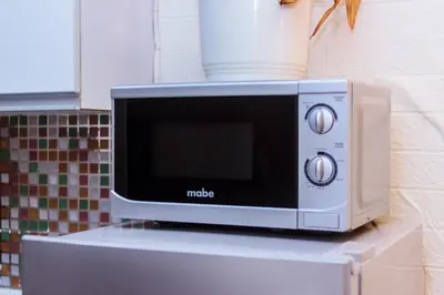 a microwave sitting on top of a table at Serene City Stay Trendy Cozy Makati Condo Fun Swim Gym Netflix 4047 in Manila