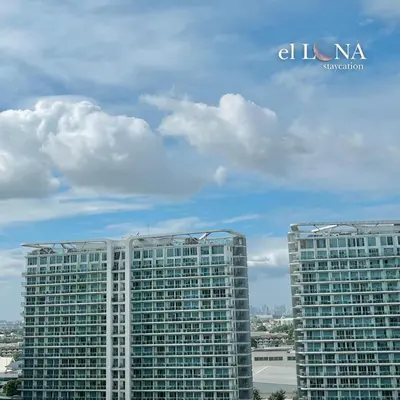 two tall buildings in a city under a cloudy sky at Serene Cove Azure in Manila