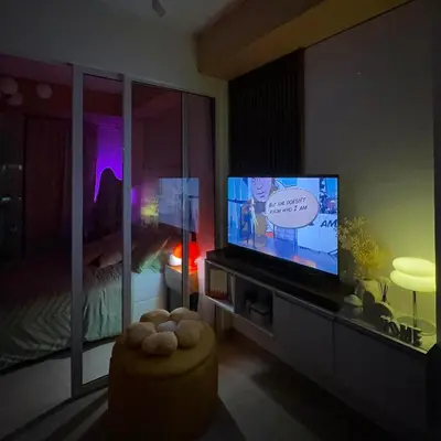 a living room with a tv and a bed at Serene Cove Azure in Manila