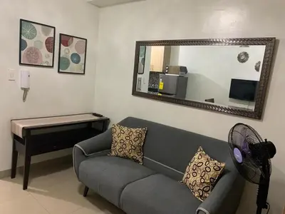 a living room with a couch and a mirror at ren&ayesha place in Manila