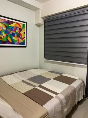 a bedroom with a bed with a window and a painting at ren&ayesha place in Manila