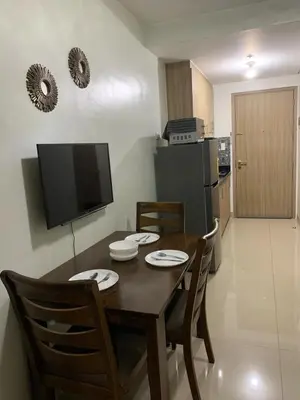 a dining room with a table and chairs and a television at ren&ayesha place in Manila