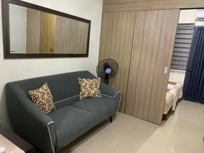 a living room with a couch and a mirror at ren&ayesha place in Manila