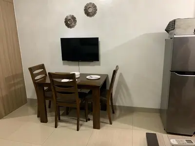 a dining room table with chairs and a television at ren&ayesha place in Manila