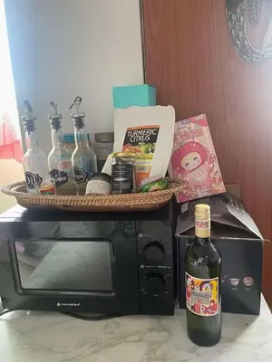 a basket on top of a microwave with a bottle of wine at Kaireese Properties in Manila
