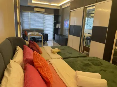 a room with a couch with pillows and a table at Mall of asia fireworks view from balcony 15floor in Manila