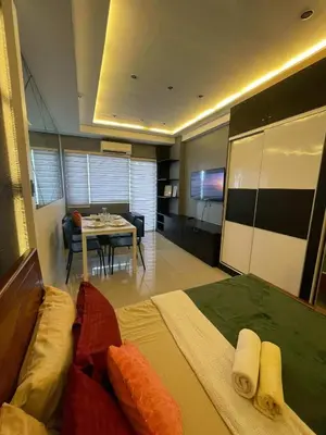 a hotel room with a bed and a dining room at Mall of asia fireworks view from balcony 15floor in Manila