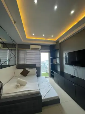 a bedroom with a bed and a flat screen tv at Mall of asia fireworks view from balcony 15floor in Manila