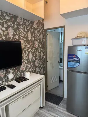 a kitchen with a refrigerator and a counter with a stove at Greenhills shopping center 2BR condominium in Manila